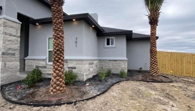A house with two palm trees in front of it.
