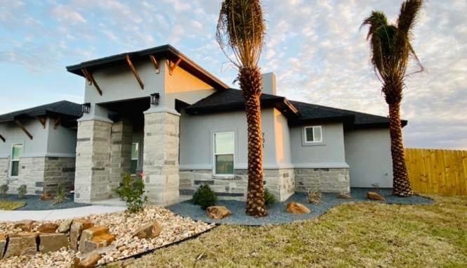 A house with two palm trees in front of it.