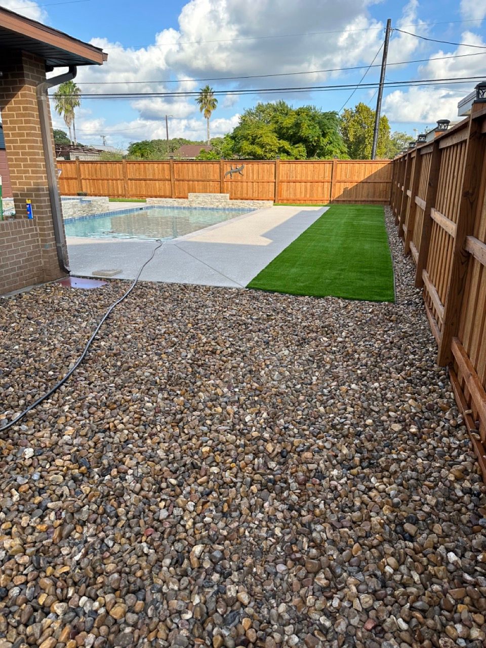 A backyard with a fence and a swimming pool.