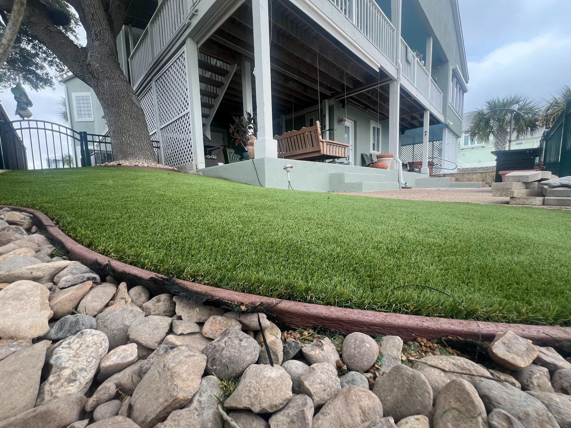 A house with a lush green lawn and rocks in front of it.