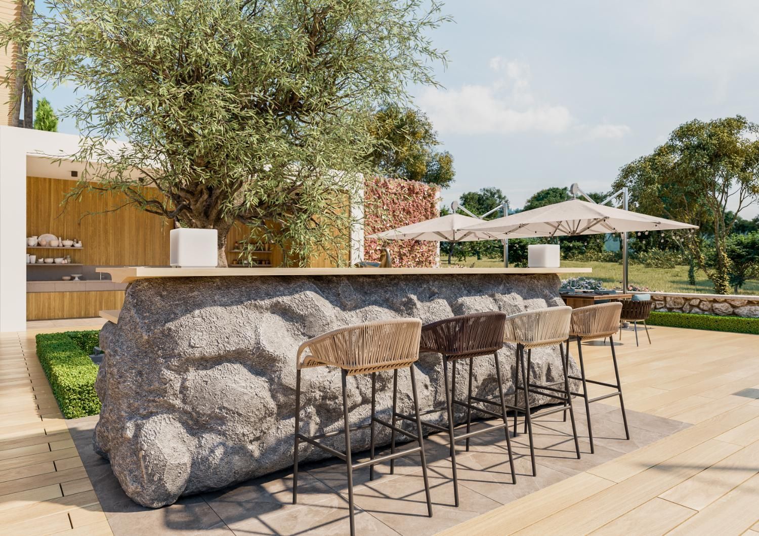 A stone bar with wicker chairs and umbrellas on a patio.