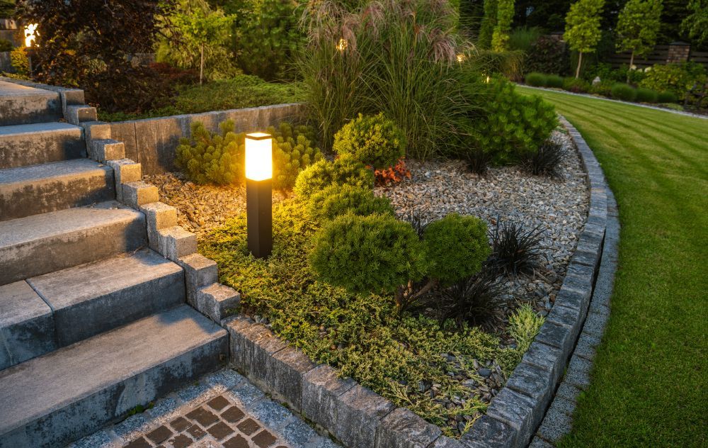 A garden with stairs and a lamp in the middle of it.