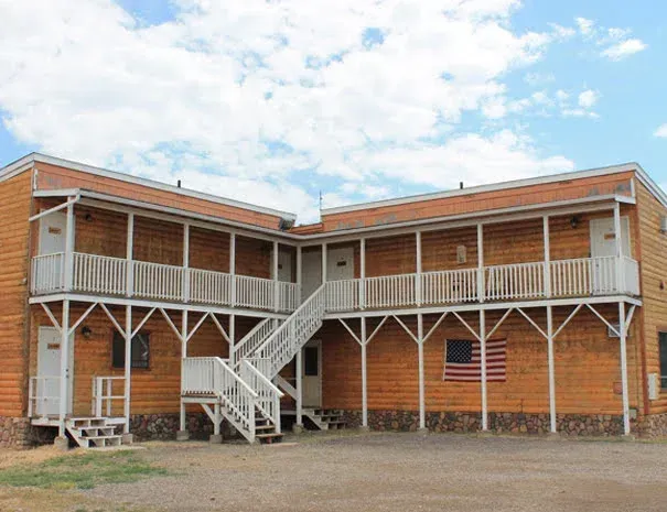 A large wooden building with stairs and an american flag on the side.