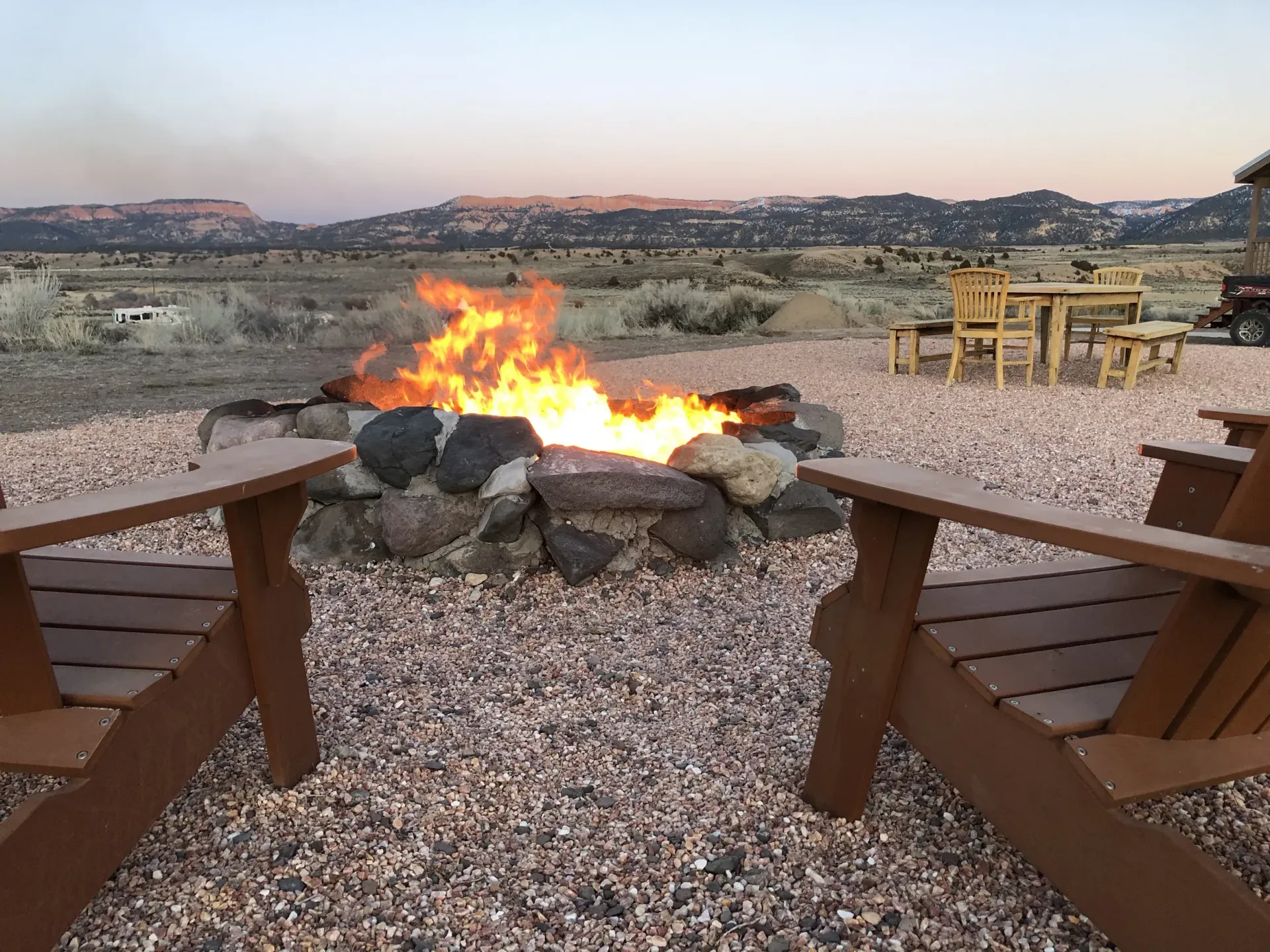 Two chairs are sitting in front of a fire pit.