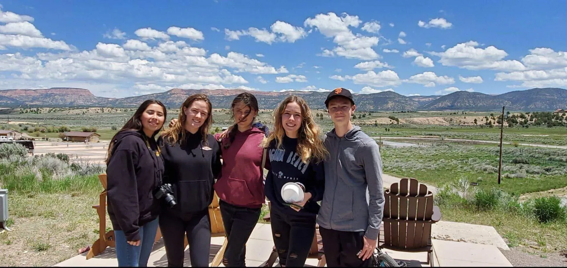 A group of young people are posing for a picture in a field.