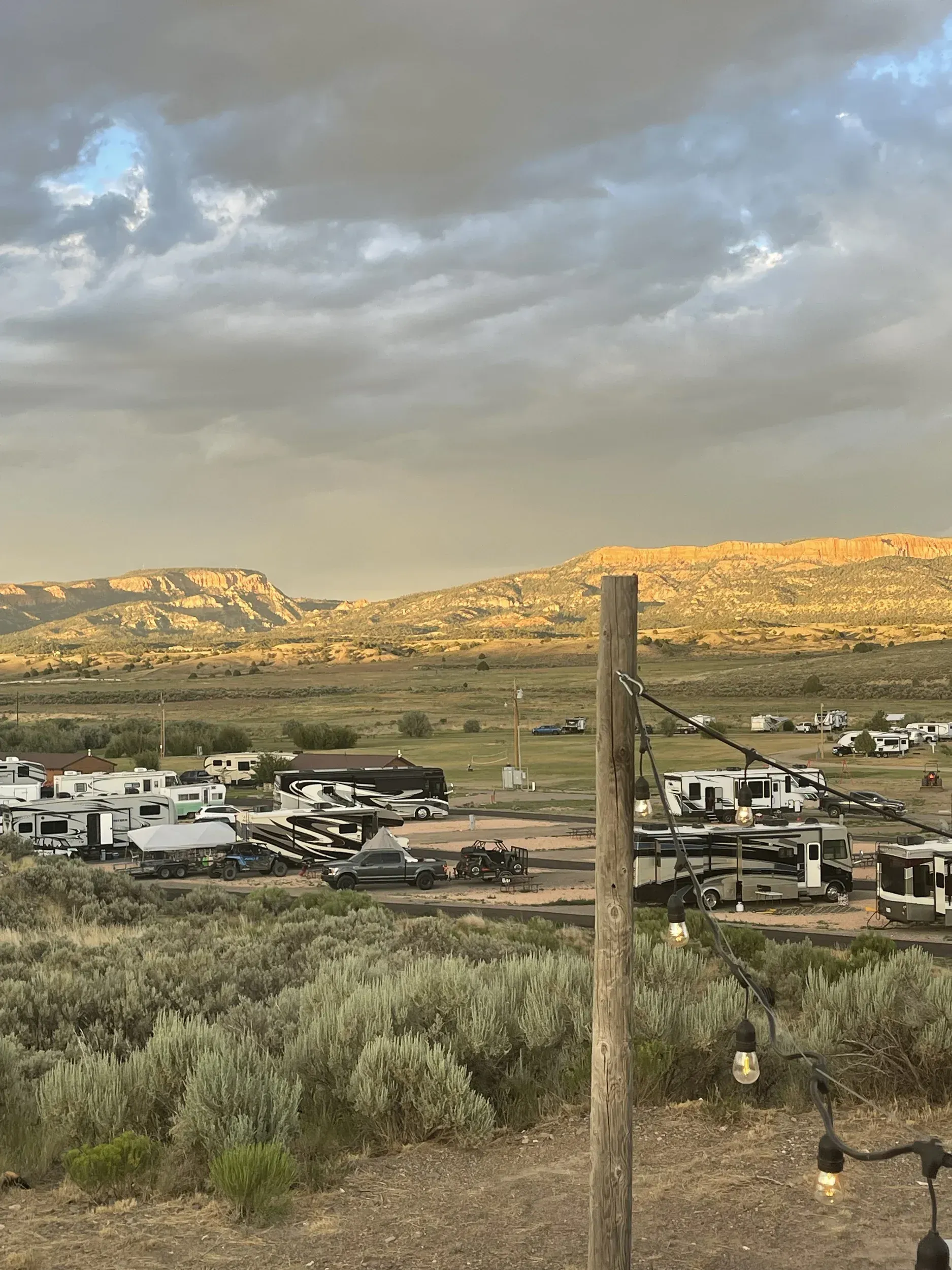 A group of rvs are parked in a field with mountains in the background.