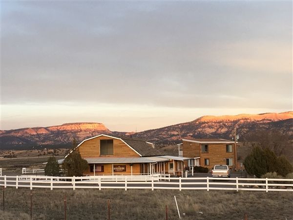 A house with a white fence and mountains in the background