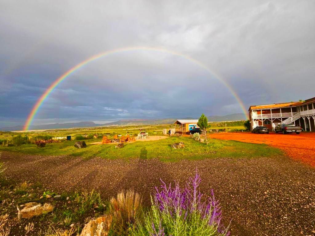 There is a rainbow in the sky over a house.