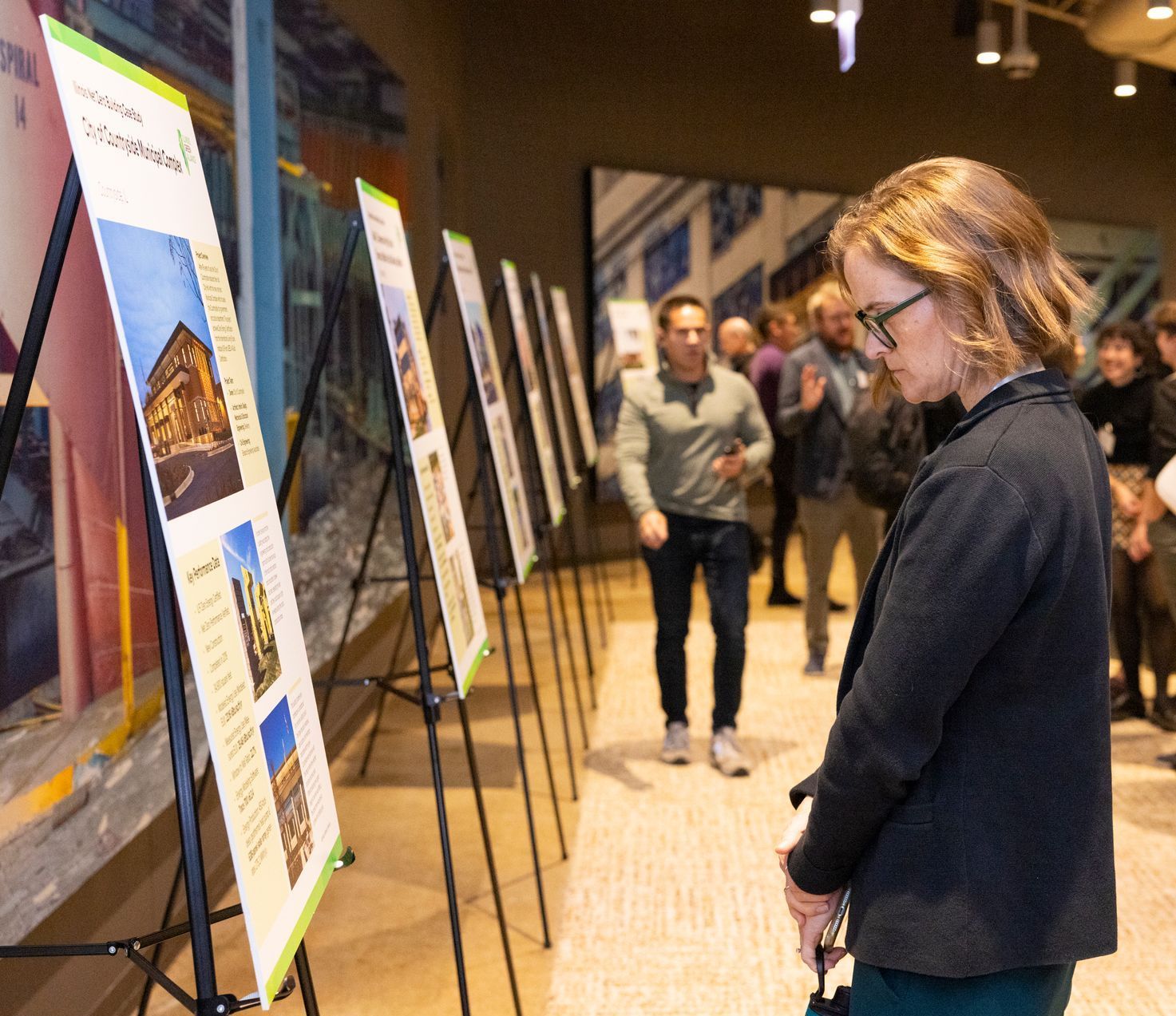 A woman is looking at a display of pictures on easels