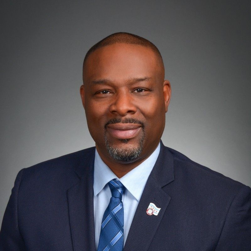 A man in a suit and tie is smiling for the camera.