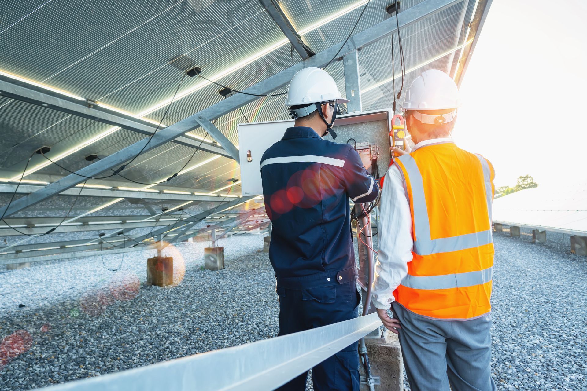 Two construction workers are working on a solar panel.