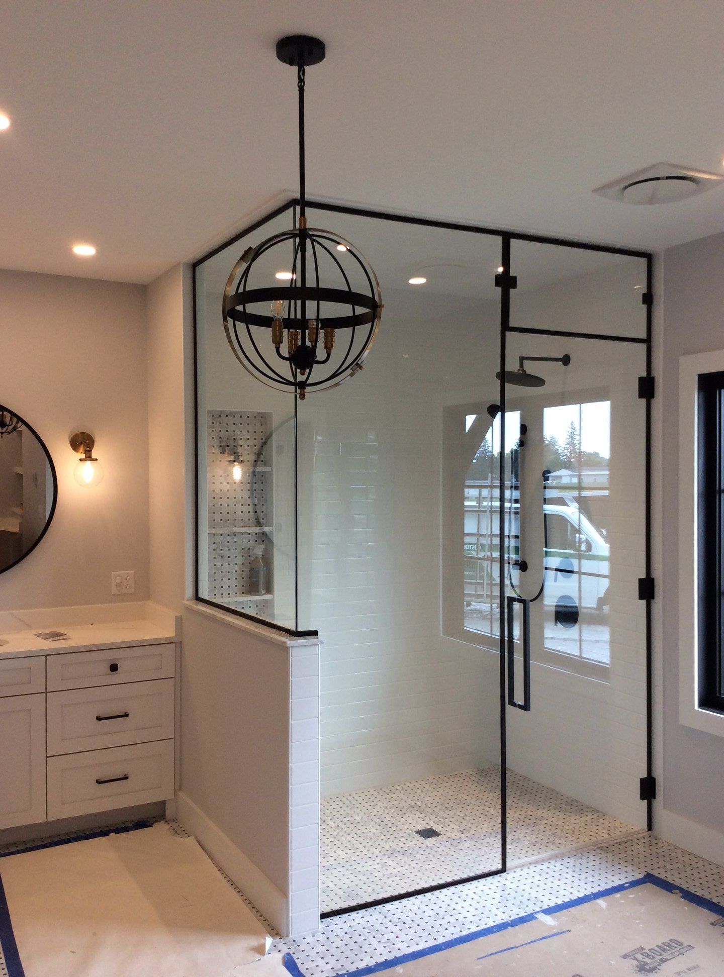 A bathroom with a walk in shower and a mirror