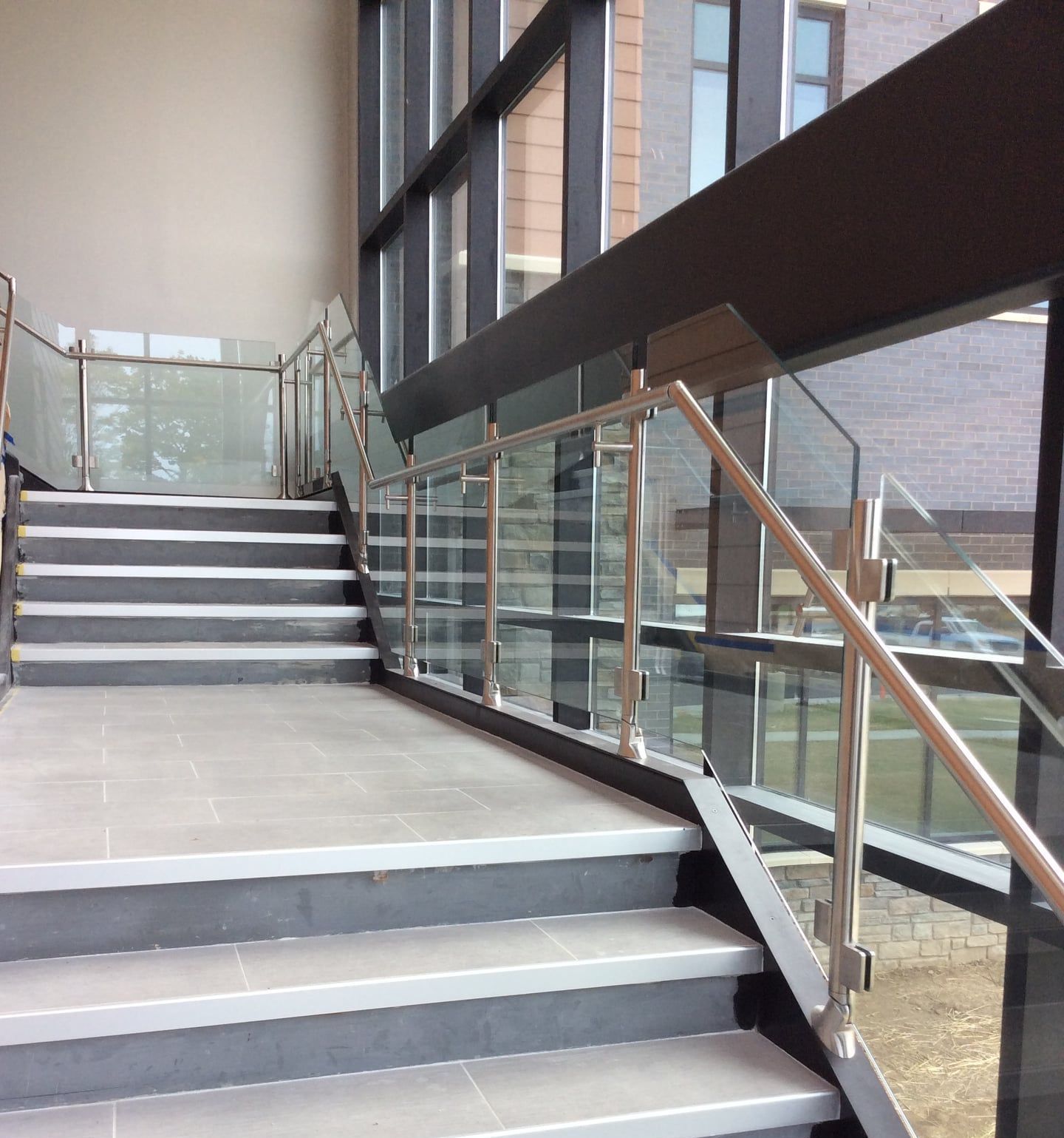 A set of stairs with a glass railing in a building
