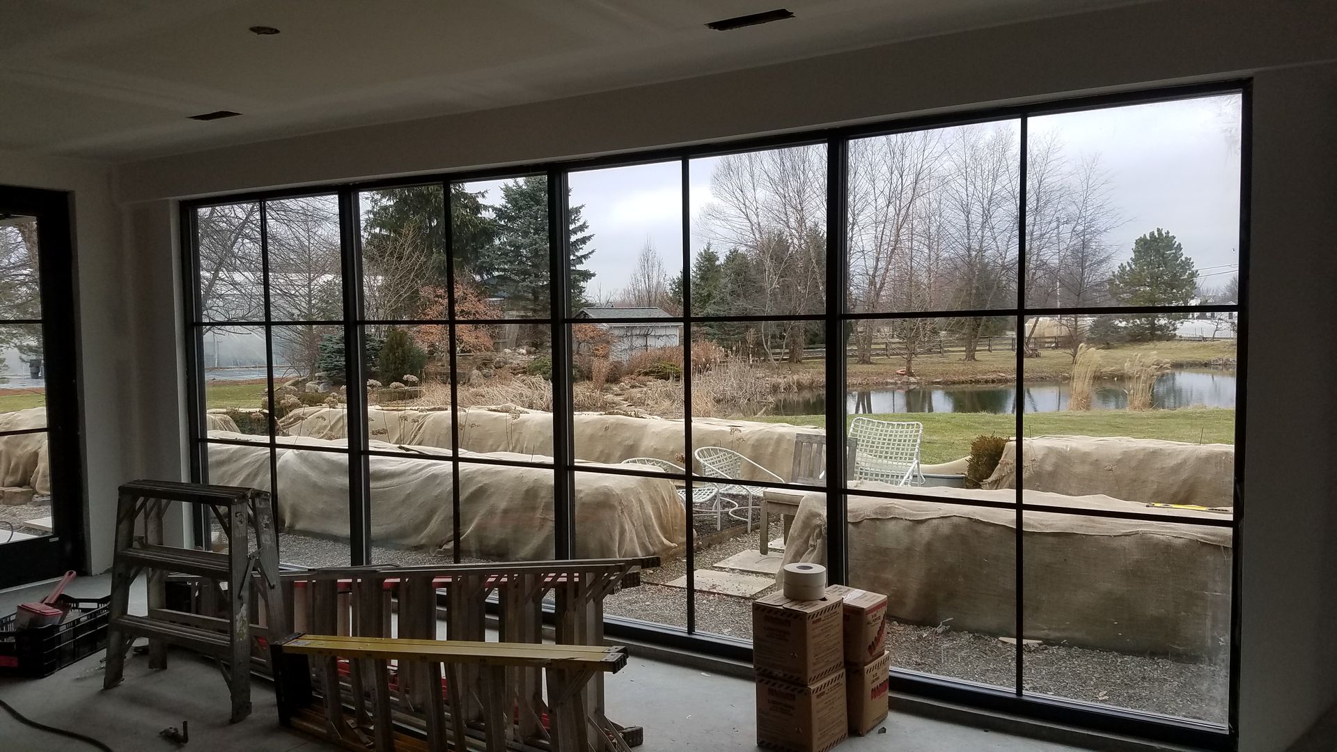 A room with a lot of windows and a ladder in it.