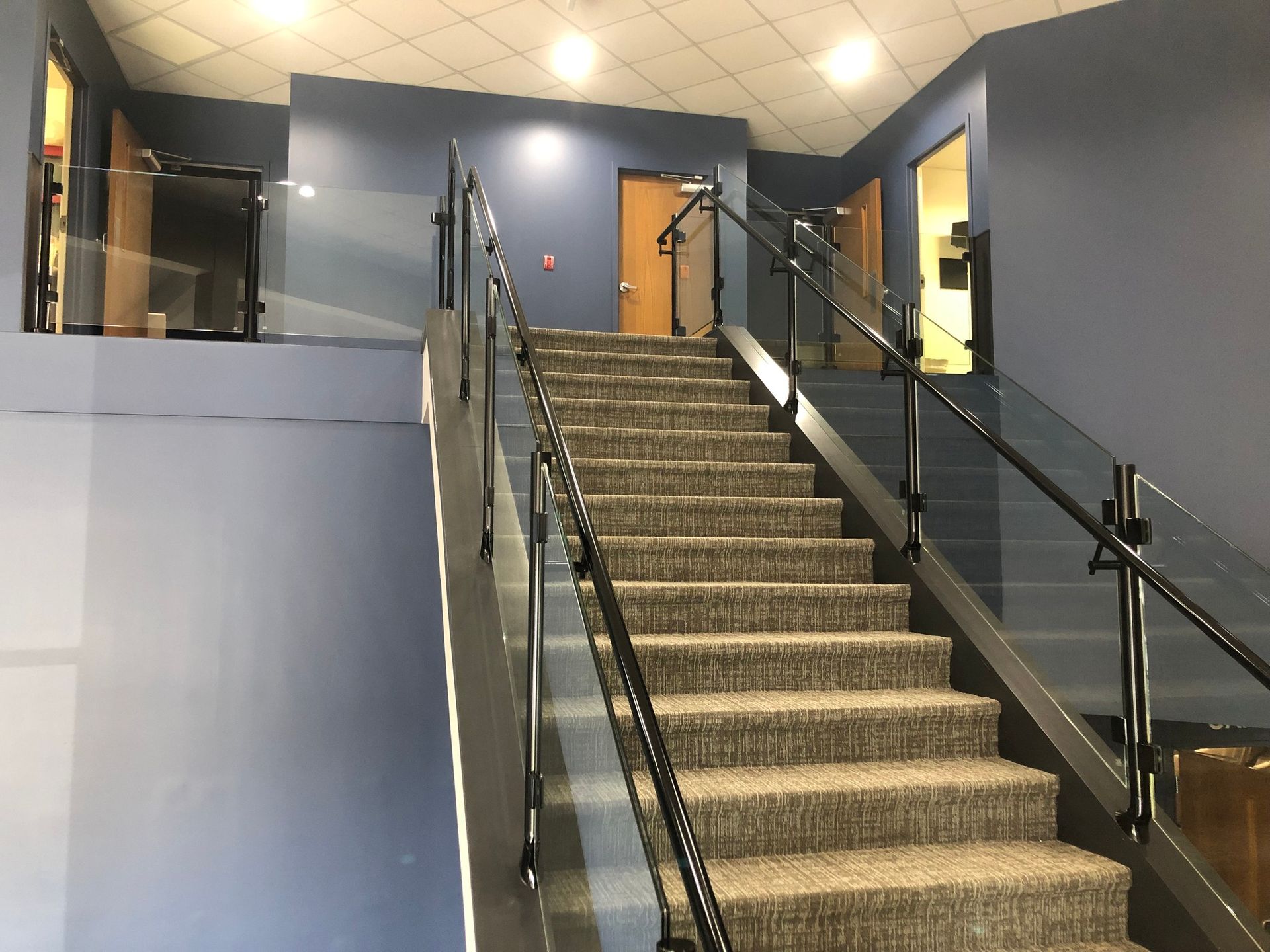 A set of stairs with a glass railing in a building