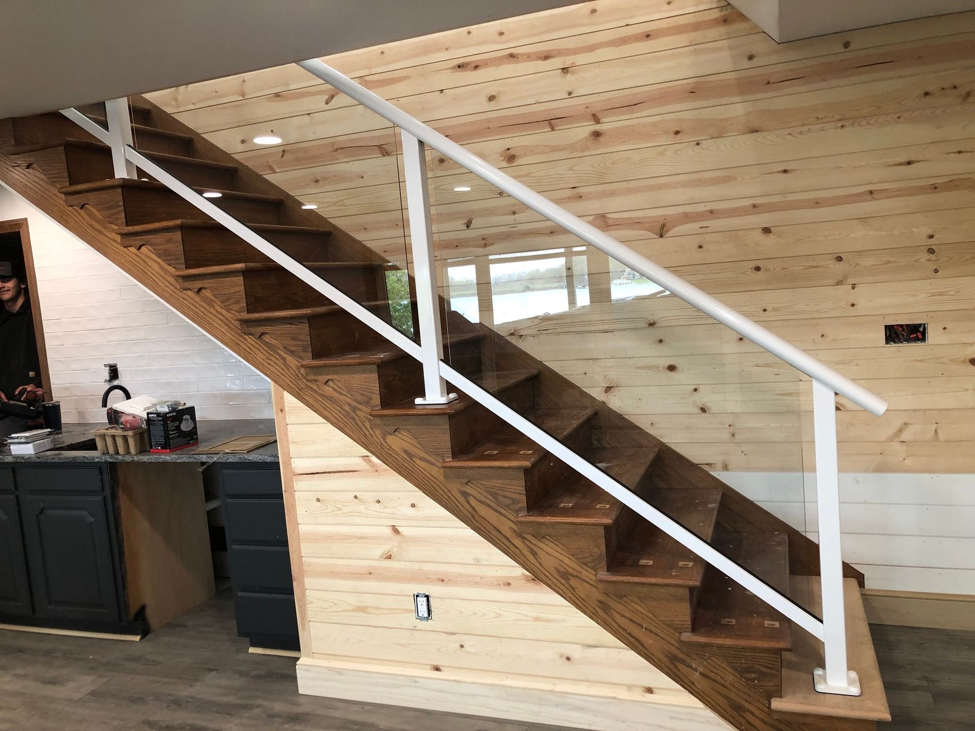 A wooden staircase with a glass railing in a house.