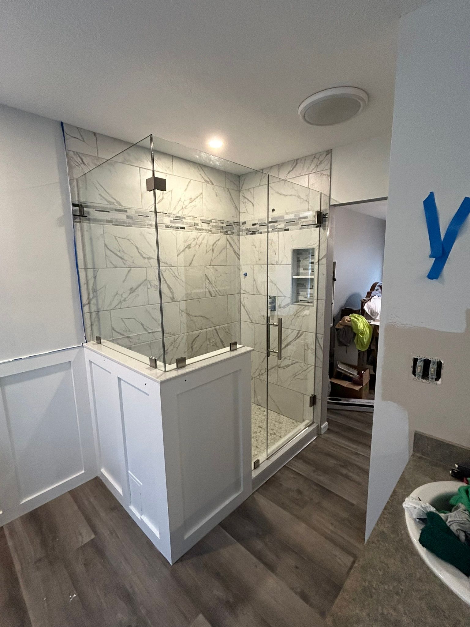 A bathroom with a walk in shower and a sink.