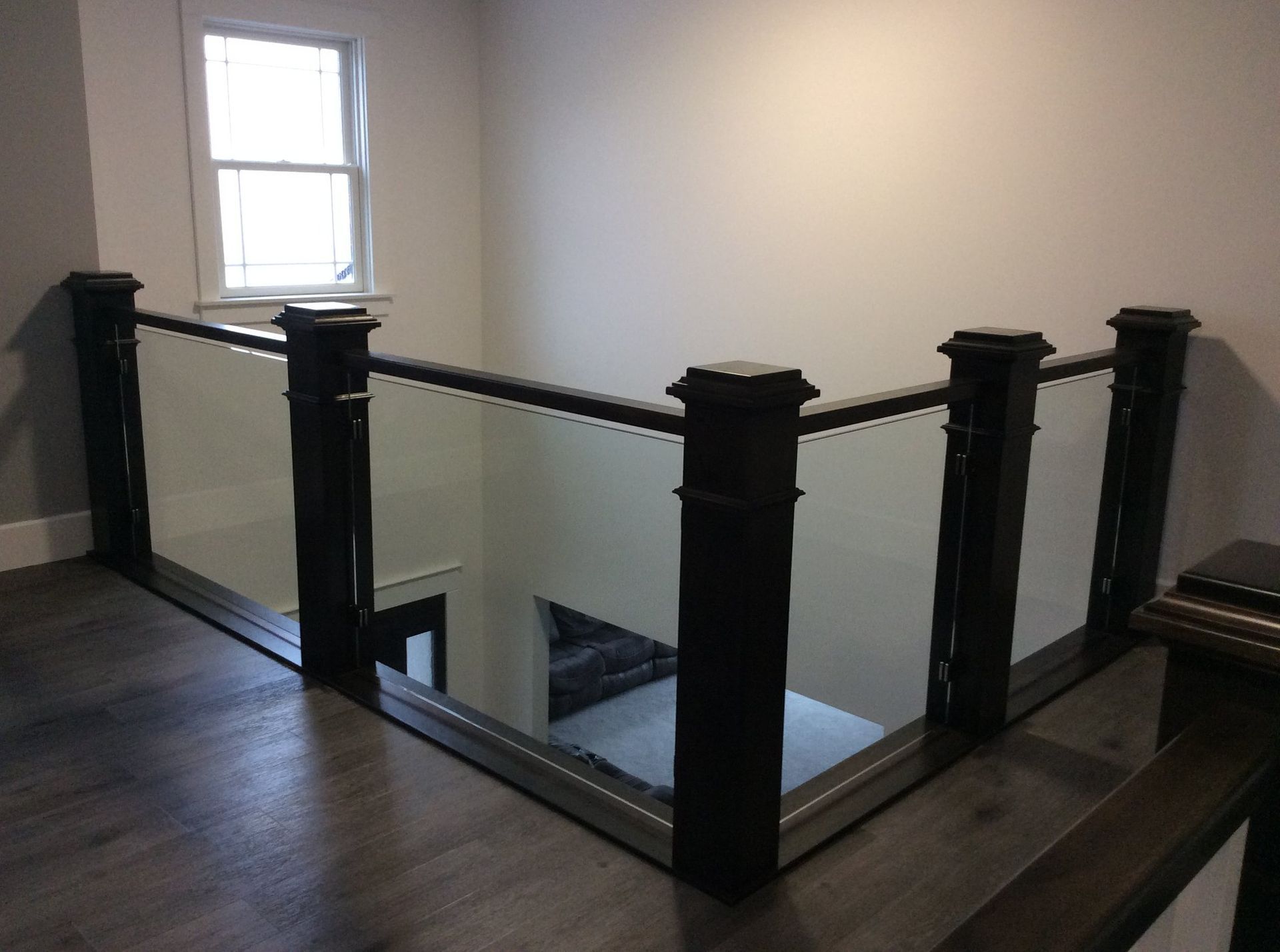A staircase with a glass railing and wooden posts.