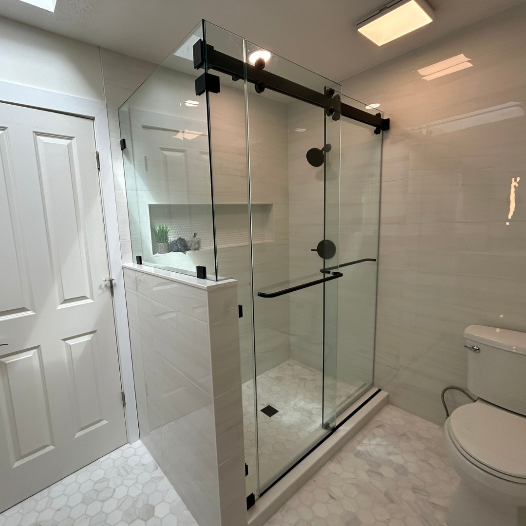 A bathroom with a sliding glass shower door and a toilet