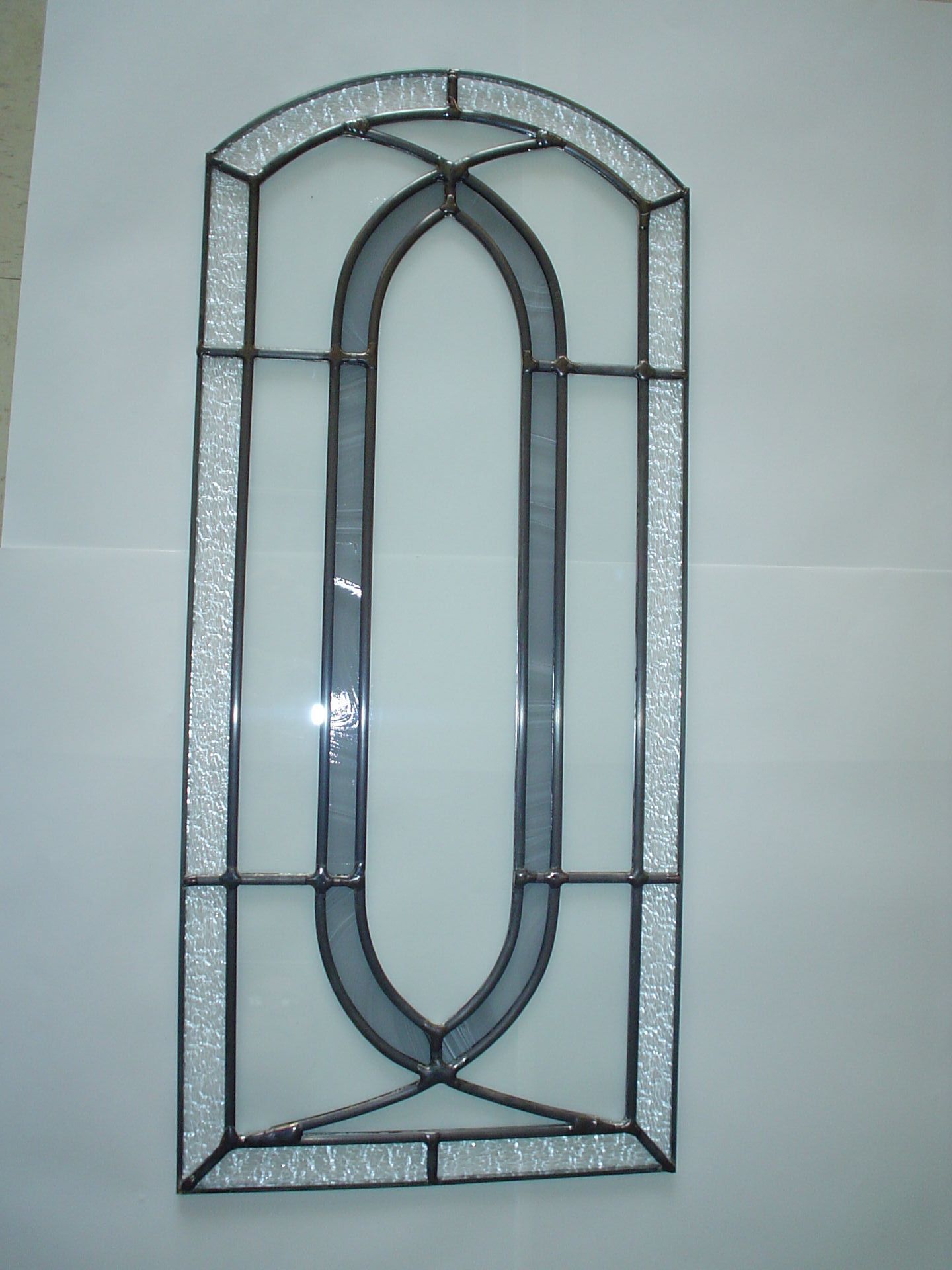 A stained glass window is hanging on a white wall