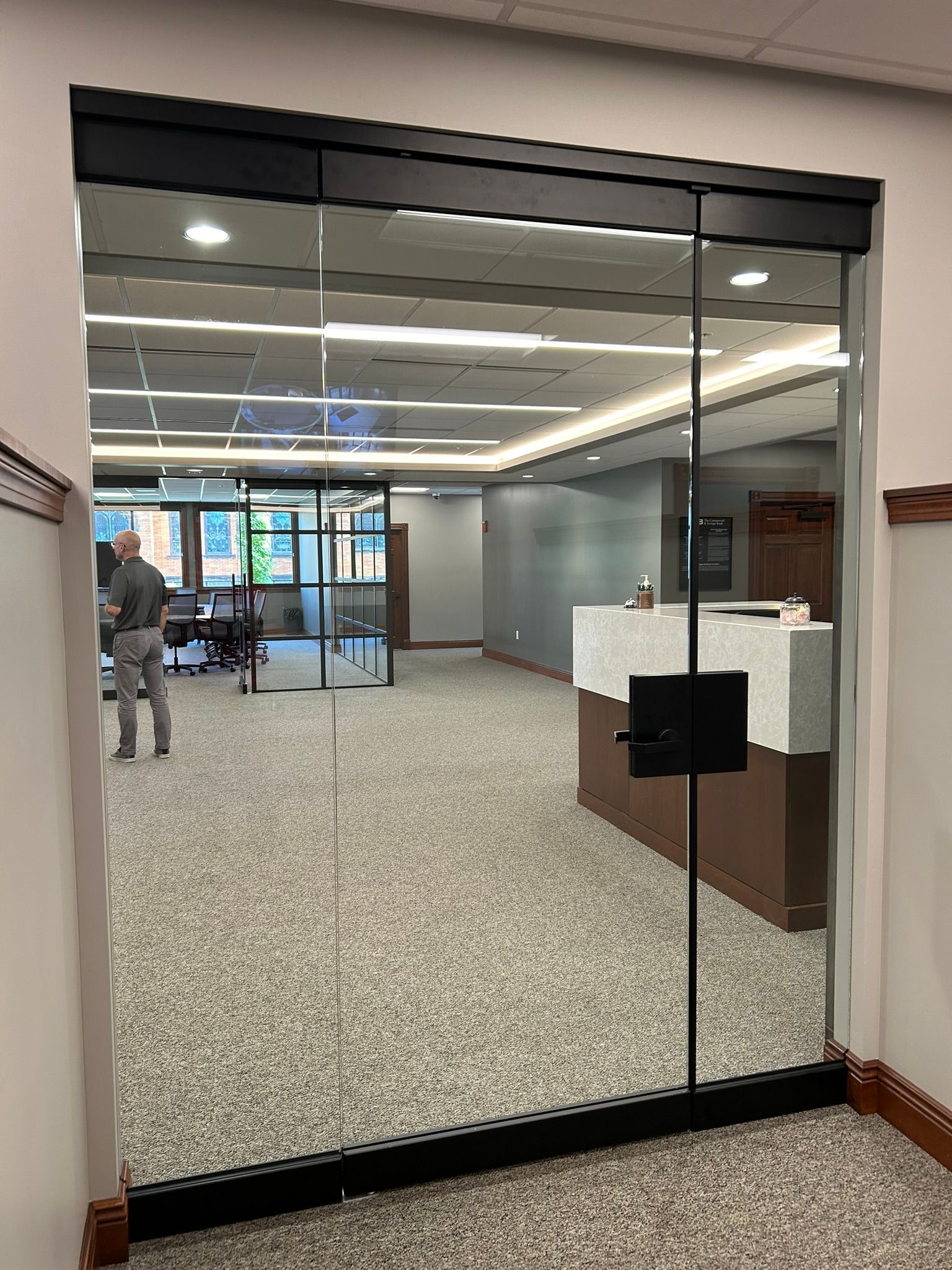 A large room with a glass door and a reception desk.