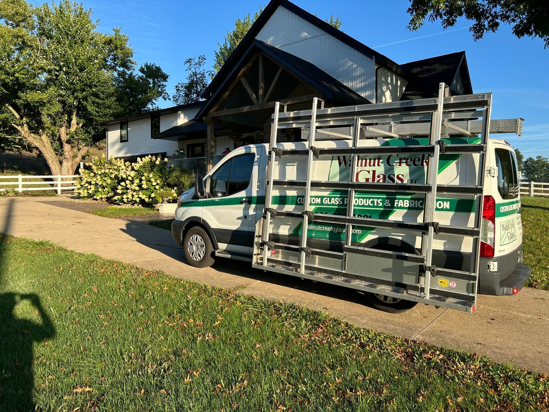A white and green van is driving down a road.