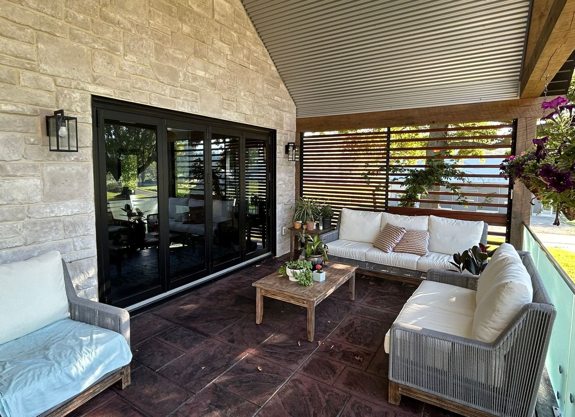 A patio with a couch , chairs , and a coffee table.
