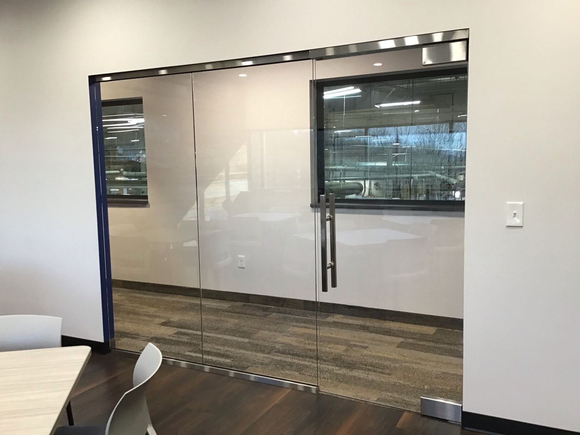 A room with a table and chairs and a glass door.