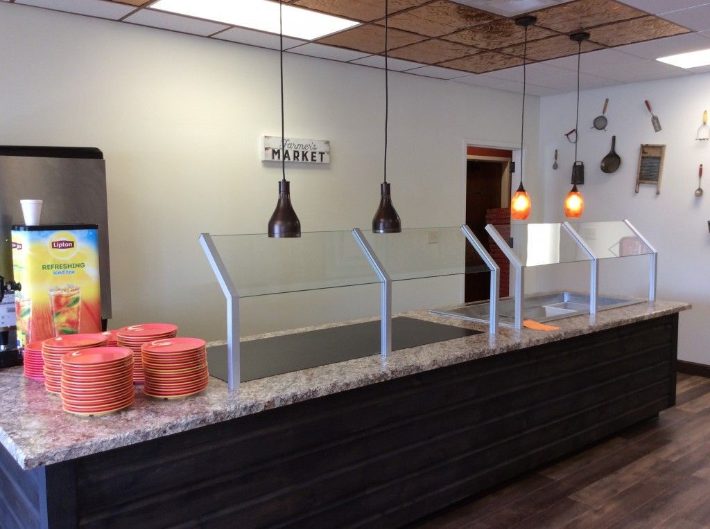 A buffet line with plates and a sign that says market