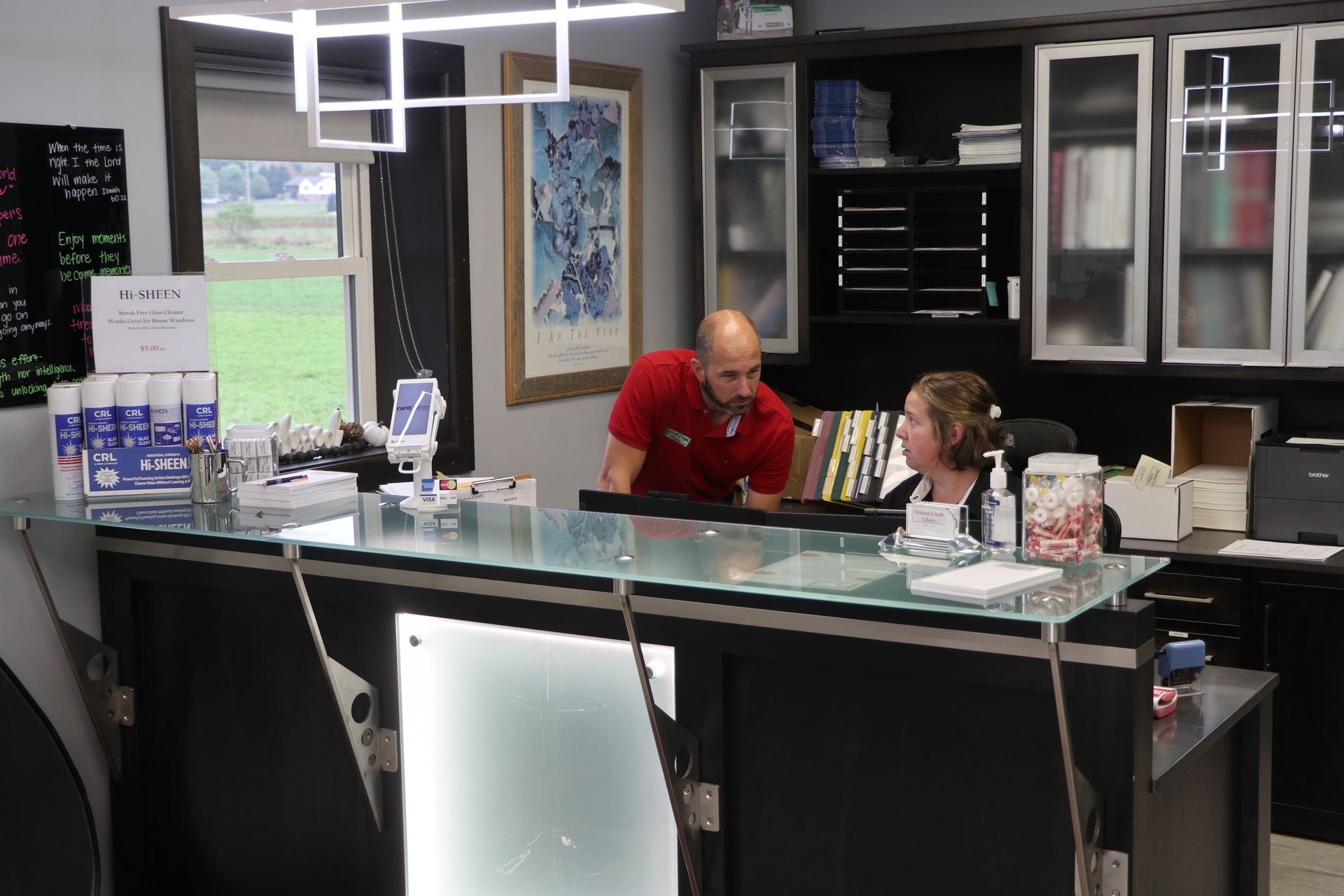 A man and a woman are sitting at a counter in an office.