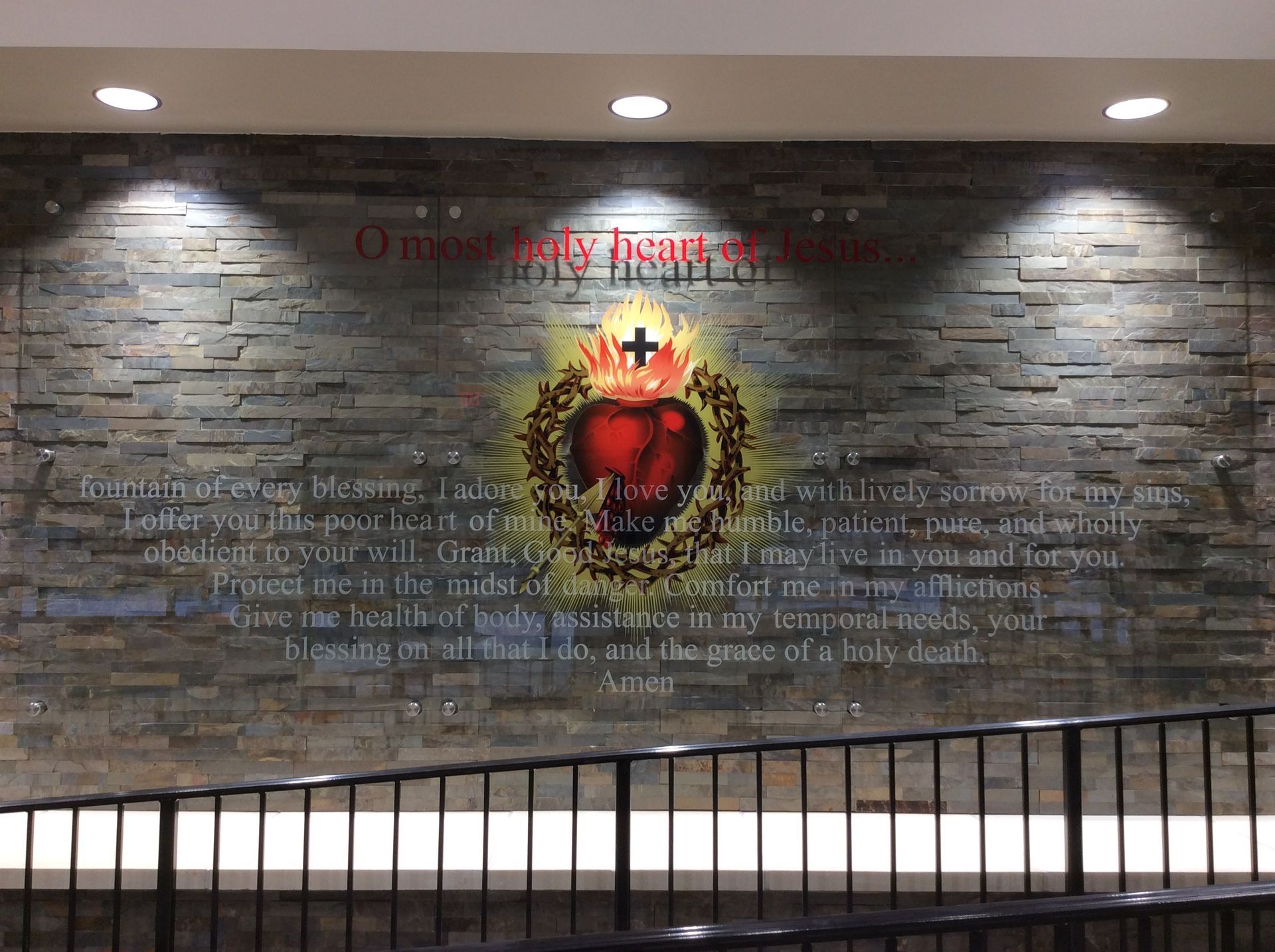 A brick wall with a painting of a heart and a cross on it.
