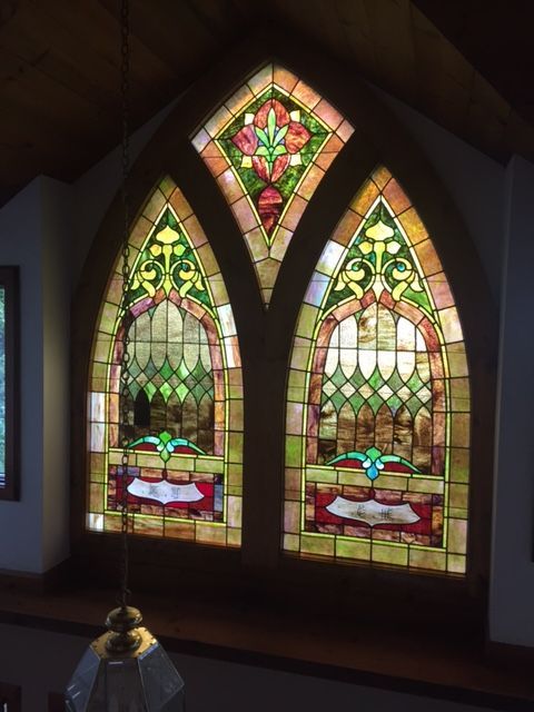 Two arched stained glass windows in a church