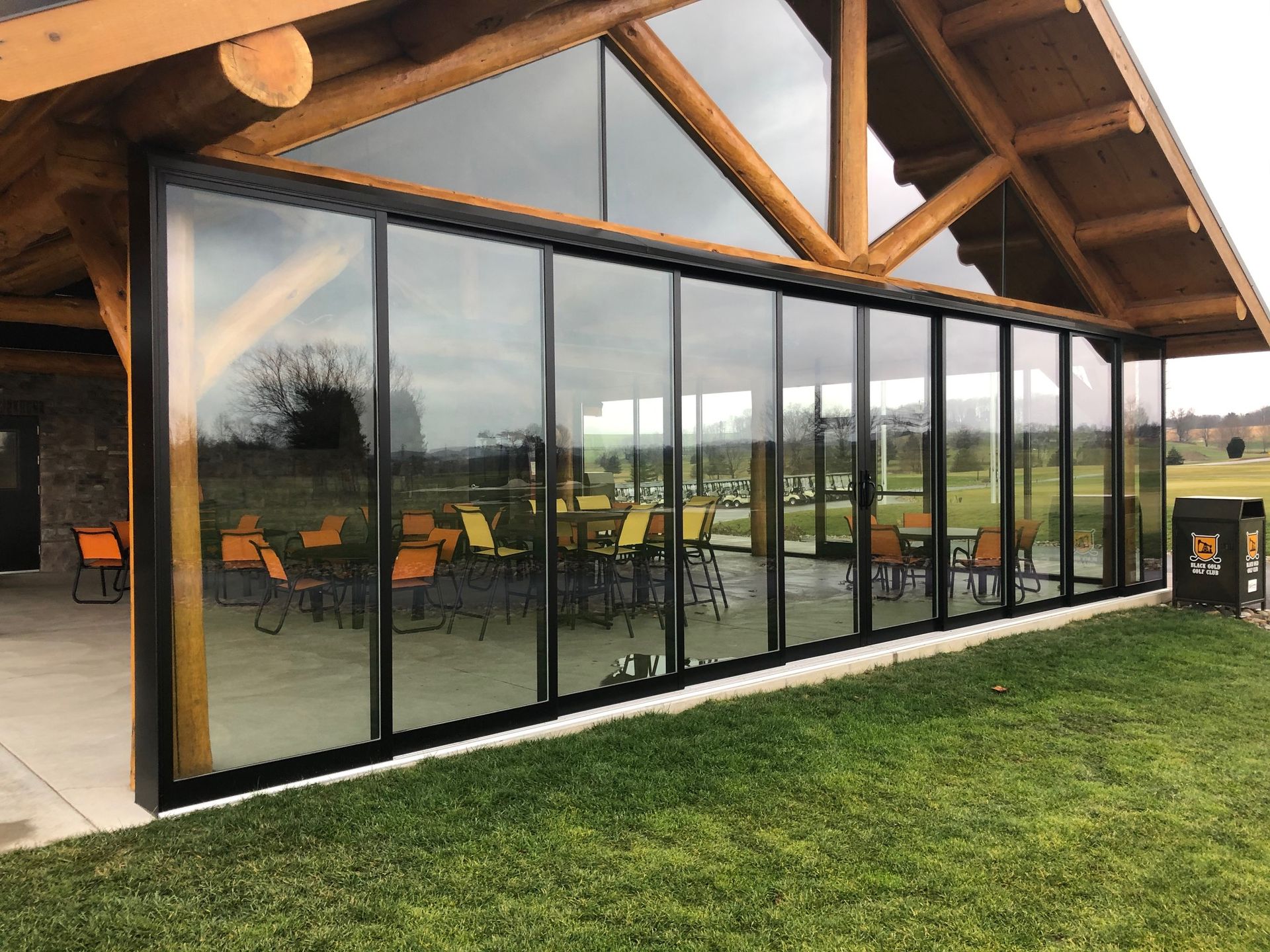 A large building with a lot of windows and tables and chairs.