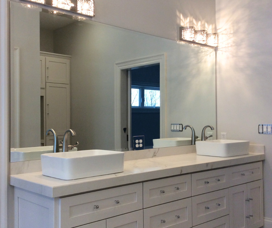 A bathroom with two sinks and a large mirror