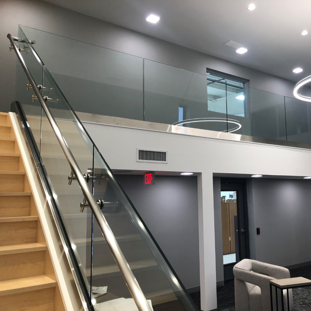 A staircase with a glass railing in a living room