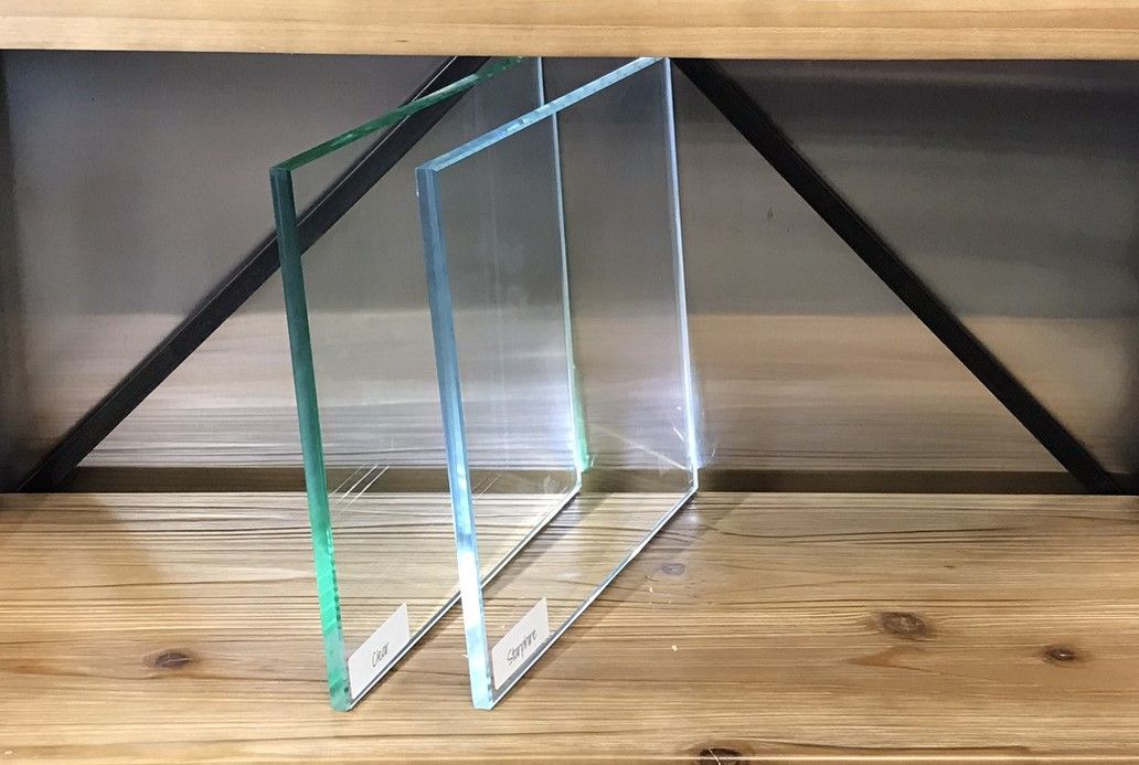 Three pieces of glass are sitting on a wooden table.