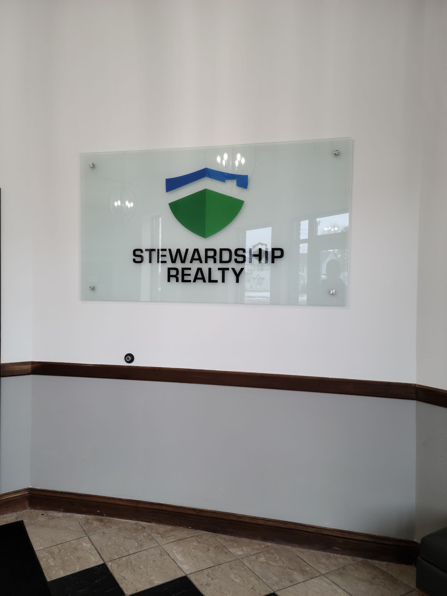 A sign on a wall that says stewardship realty