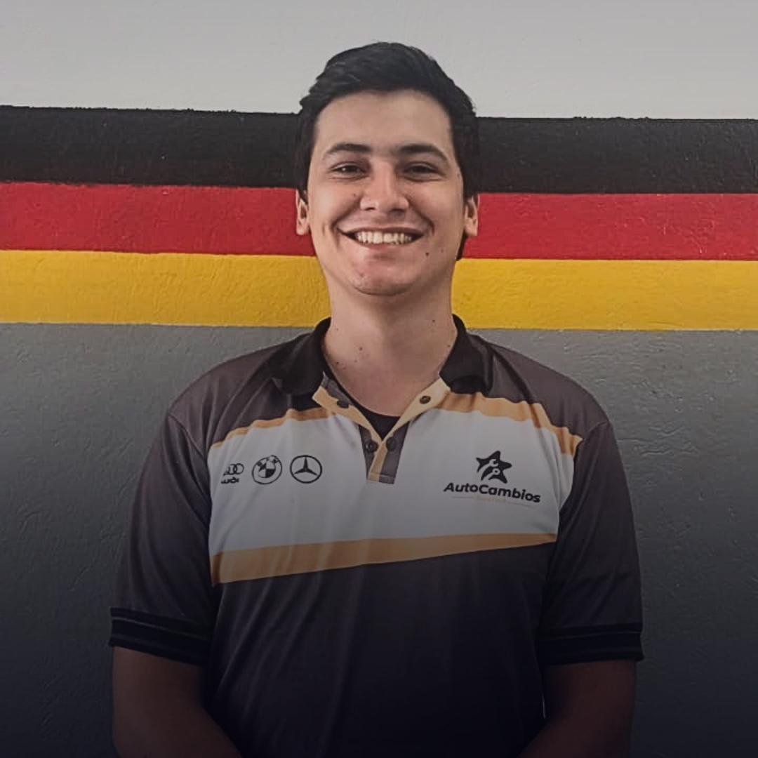 A young man is standing in front of a wall with a german flag painted on it.