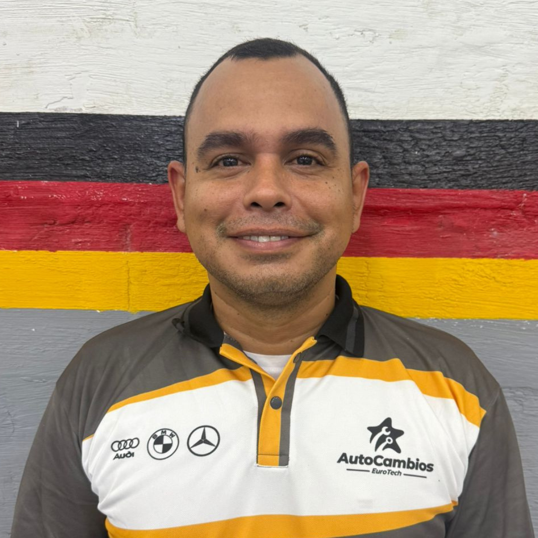 A man in a black and yellow shirt is standing in front of a german flag