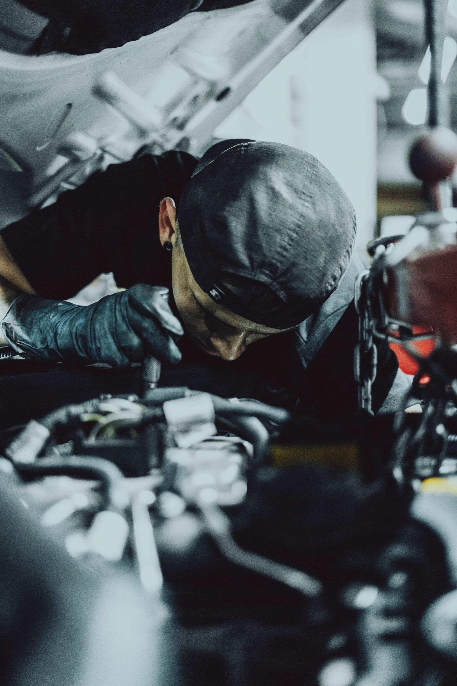 A man is working under the hood of a car.
