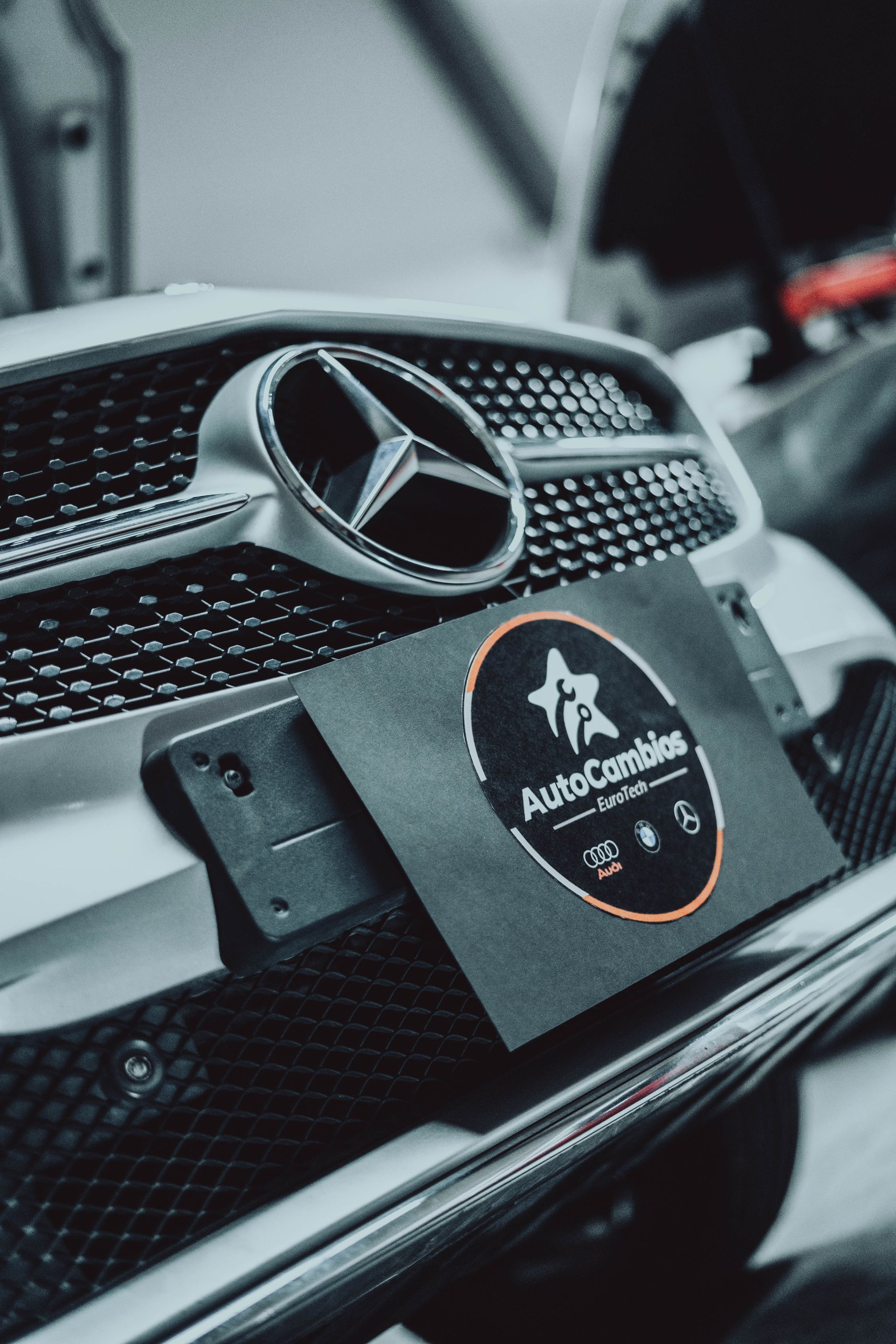 The front of a mercedes with a license plate that says autocambios