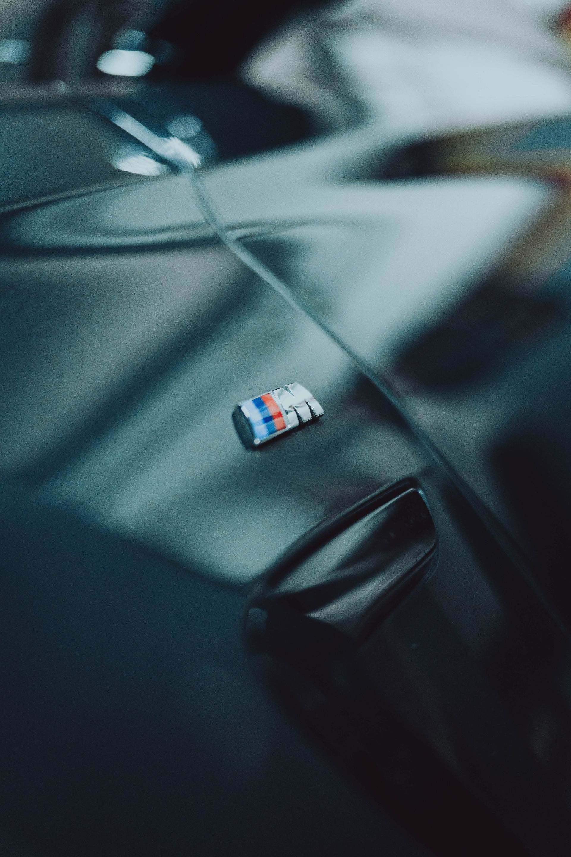 A close up of a bmw emblem on the side of a car.