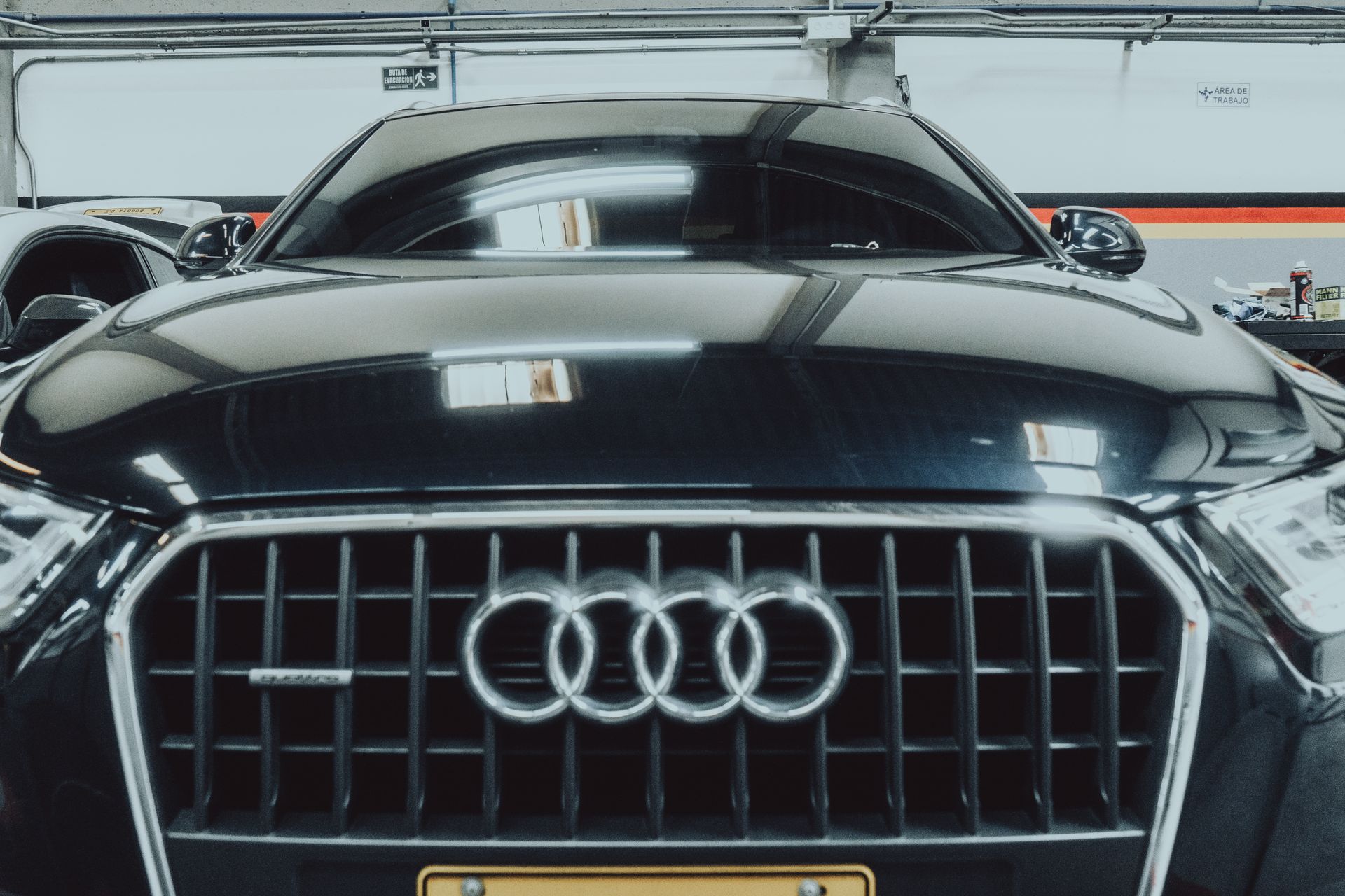 A black audi car is parked in a garage.