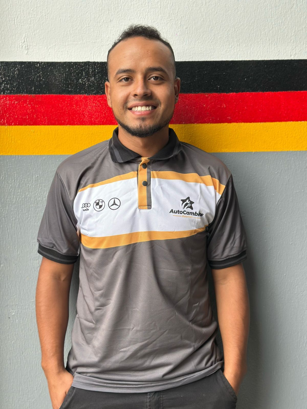 A man wearing a polo shirt with the word mercedes on it