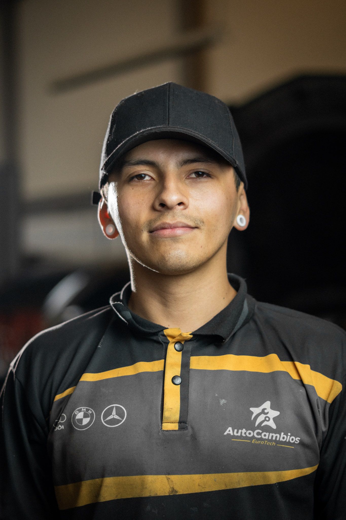 A man wearing a hat and a shirt that says autocambios