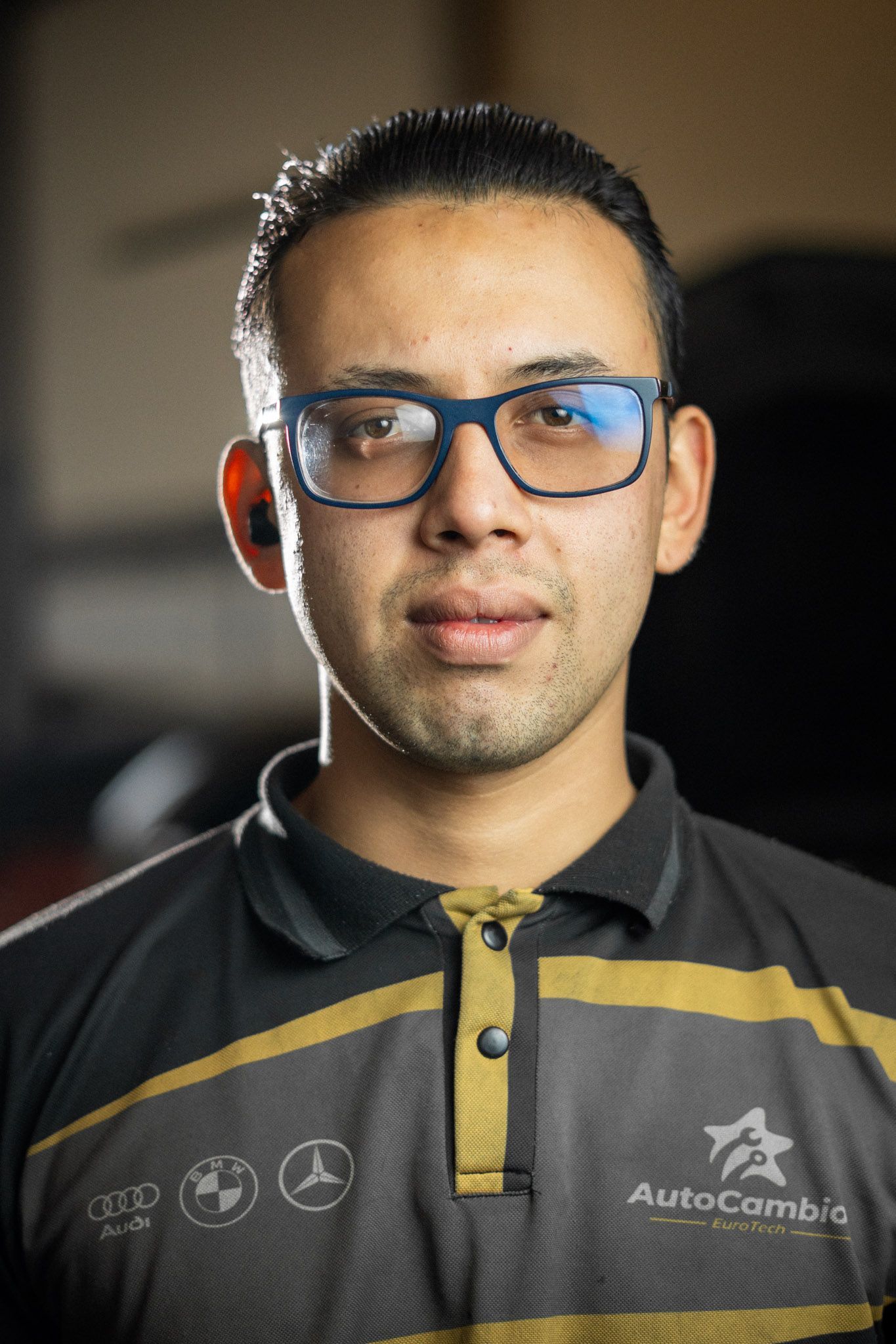 A man wearing glasses and a shirt that says autocambio