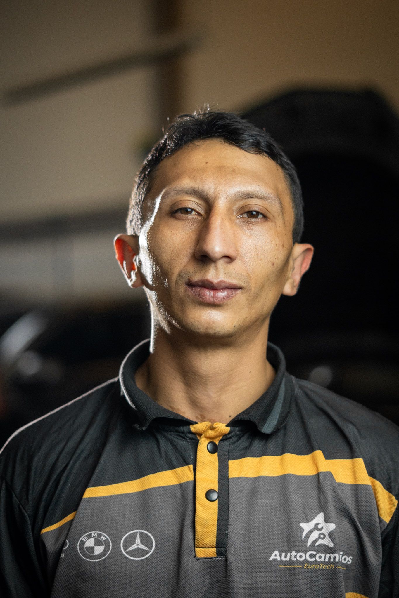 A man wearing a black and yellow shirt with the word auto on it