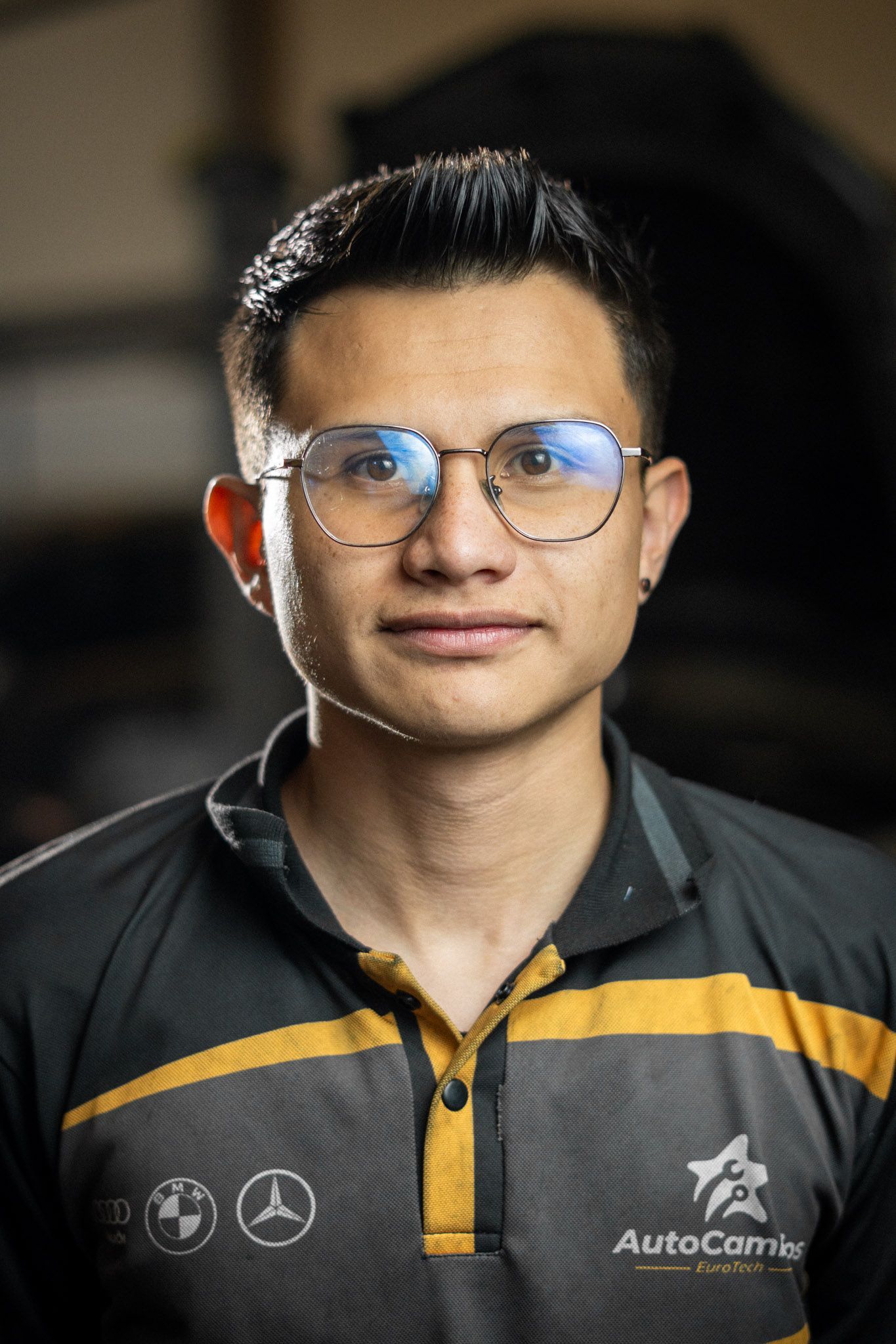 A man wearing glasses and a shirt that says autocamion