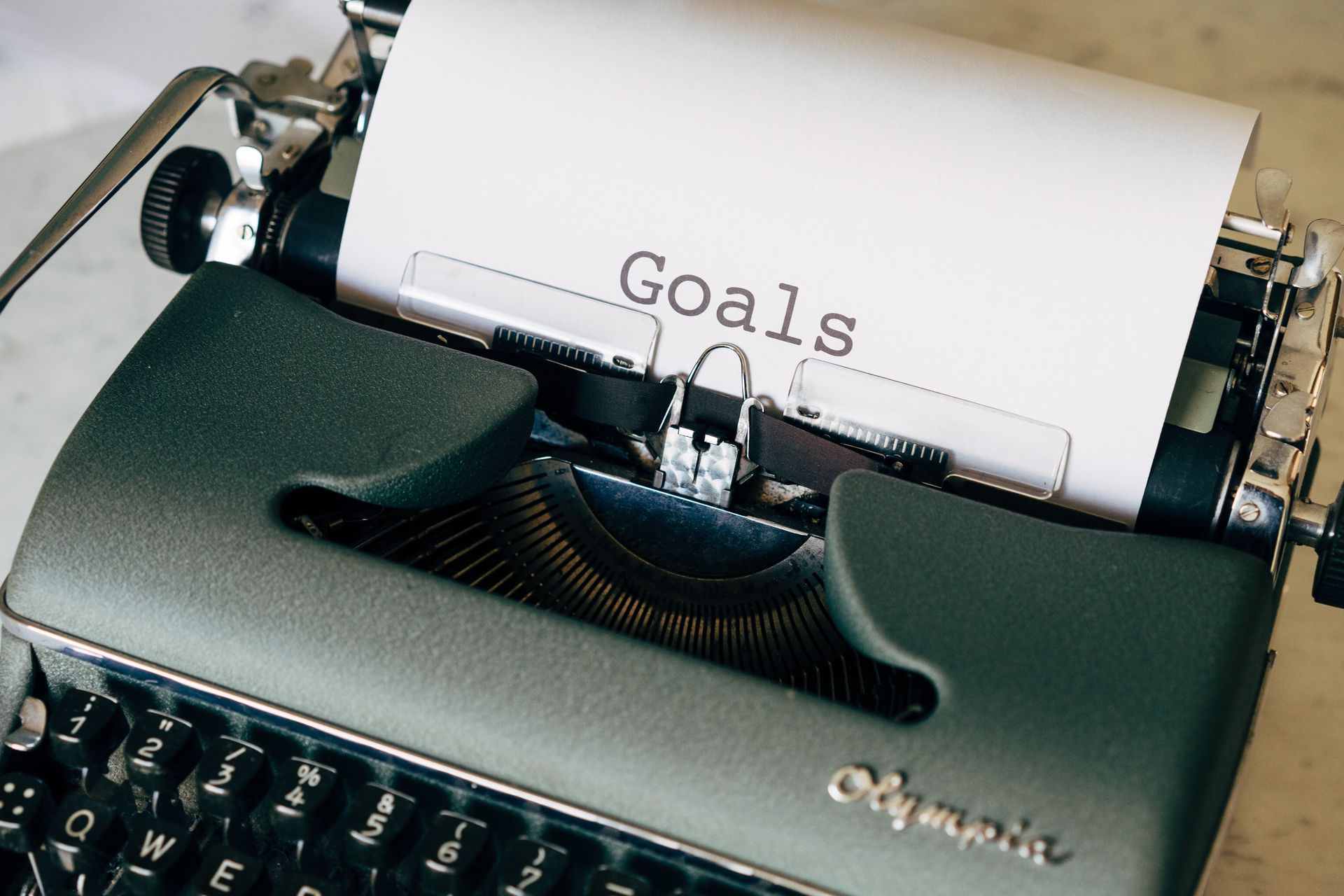 A typewriter with a piece of paper that says goals on it