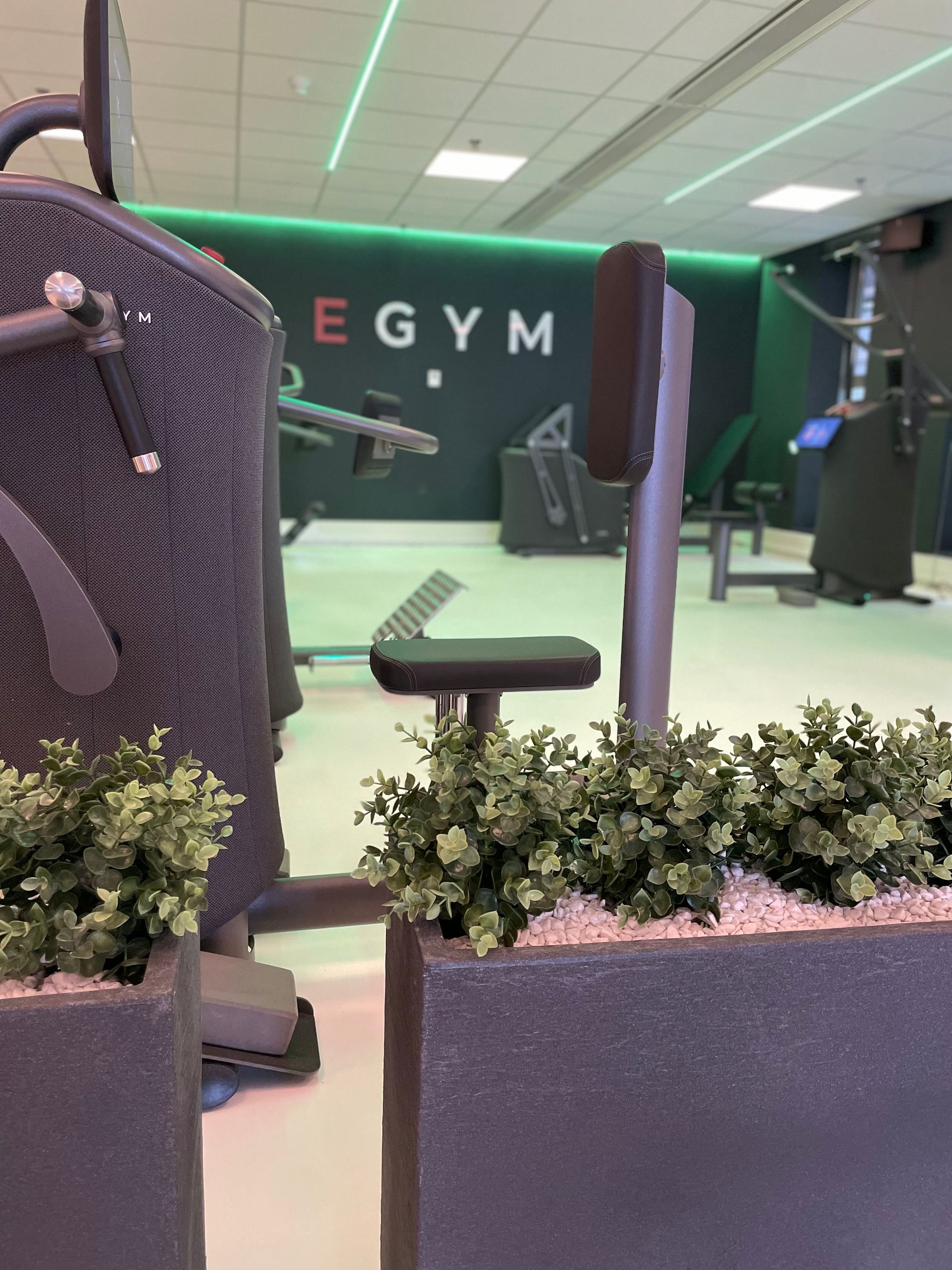 Een sportschool vol met fitnessapparatuur en televisies.